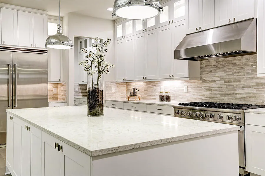 Custom white kitchen renovation in Leonardtown MD by Advanced Kitchen Concepts featuring quartz waterfall island, commercial-style range, and glass tile backsplash.